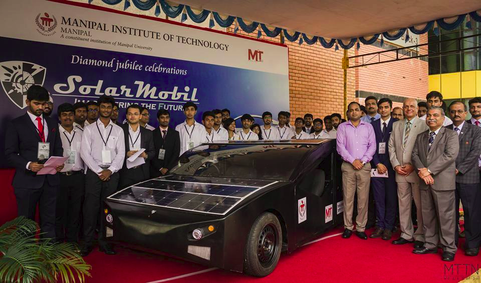 SolarMobil's SM S-1 solar car, a four-seater passenger vehicle, showing its side profile and solar panel roof.